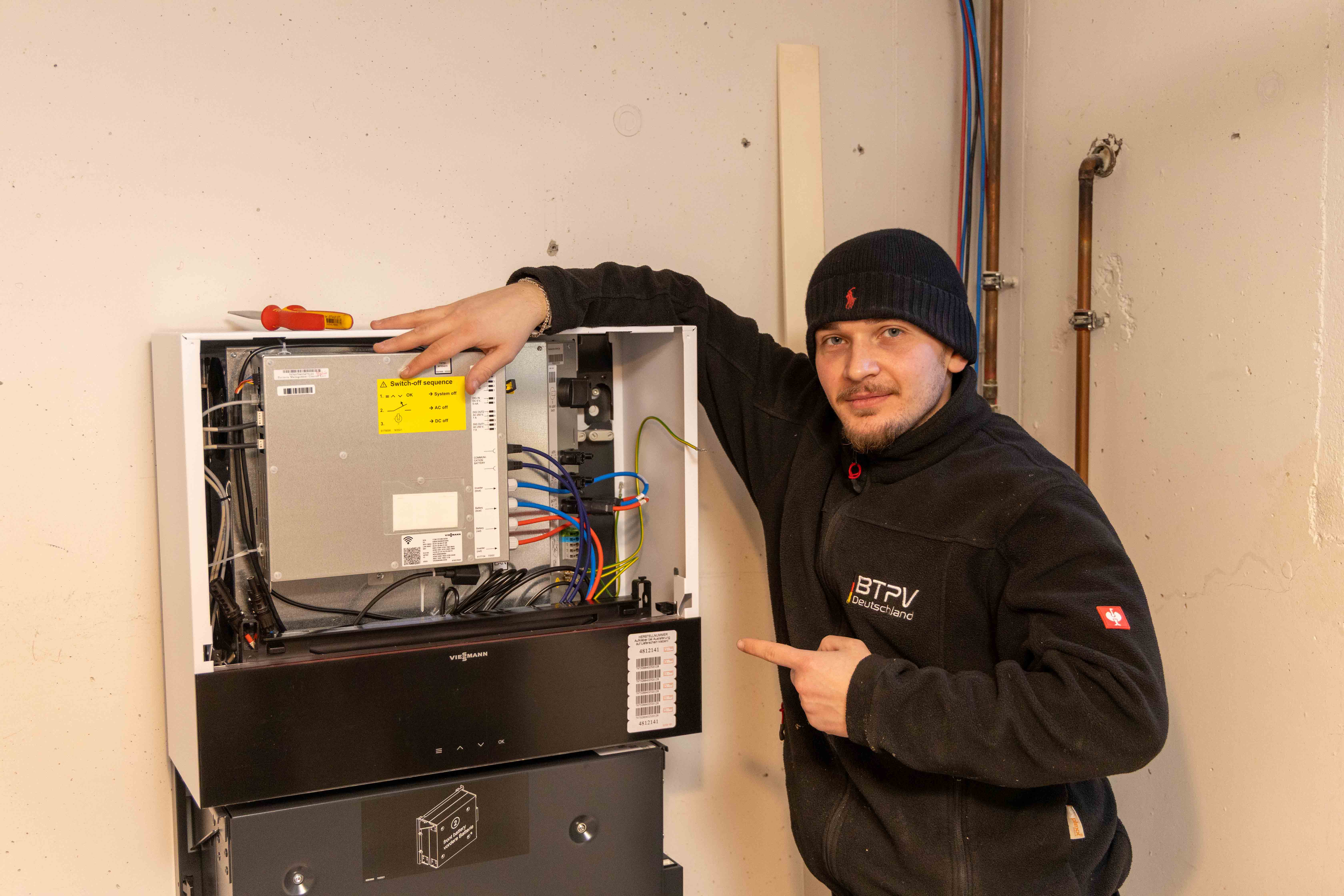 BTPV Elektriker installiert Stromspeicher – zeigt Innenansicht der Batterie